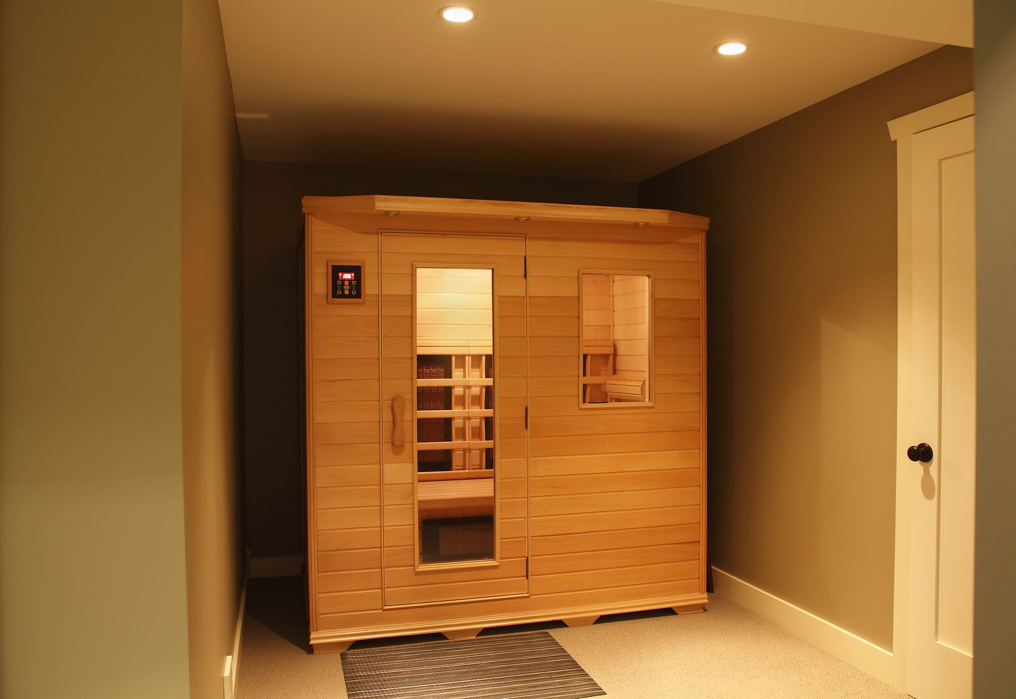 Applying Essential Sauna Wood Oil with a wide brush along the grain of cedar sauna bench wood